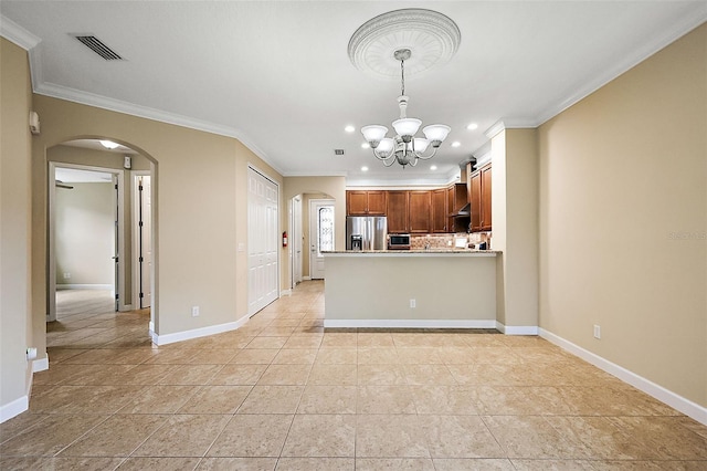 kitchen featuring a notable chandelier, kitchen peninsula, stainless steel fridge, decorative light fixtures, and ornamental molding