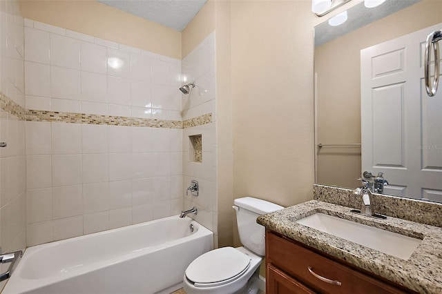 full bathroom featuring a textured ceiling, vanity, toilet, and tiled shower / bath