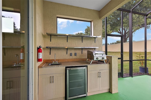 kitchen featuring stainless steel refrigerator, sink, and concrete flooring