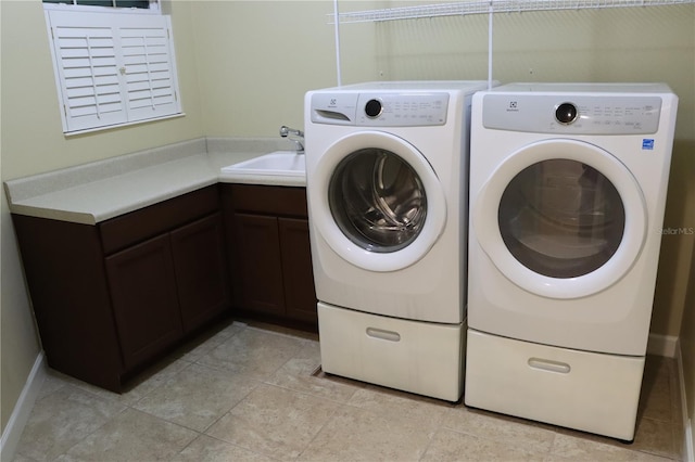 clothes washing area featuring cabinets, light tile patterned floors, washing machine and dryer, and sink