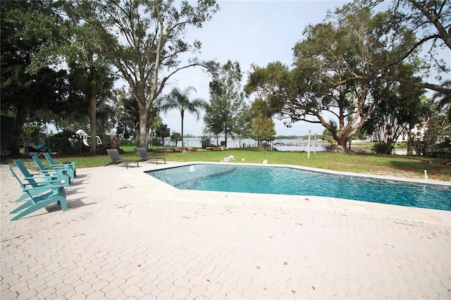 view of pool featuring a lawn and a patio