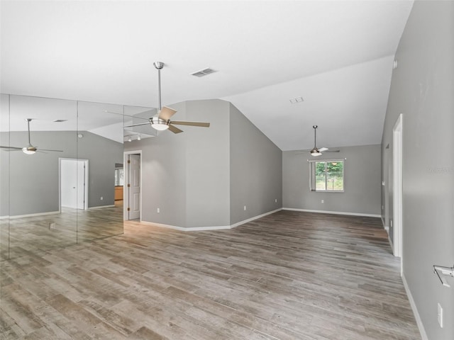 unfurnished living room featuring hardwood / wood-style floors and lofted ceiling