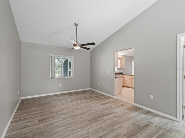 spare room featuring high vaulted ceiling, light hardwood / wood-style flooring, and ceiling fan