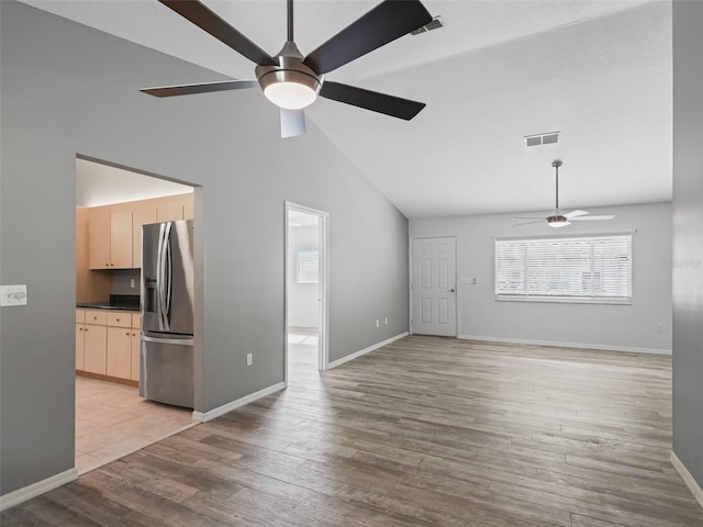 unfurnished living room featuring ceiling fan, light wood-type flooring, and high vaulted ceiling