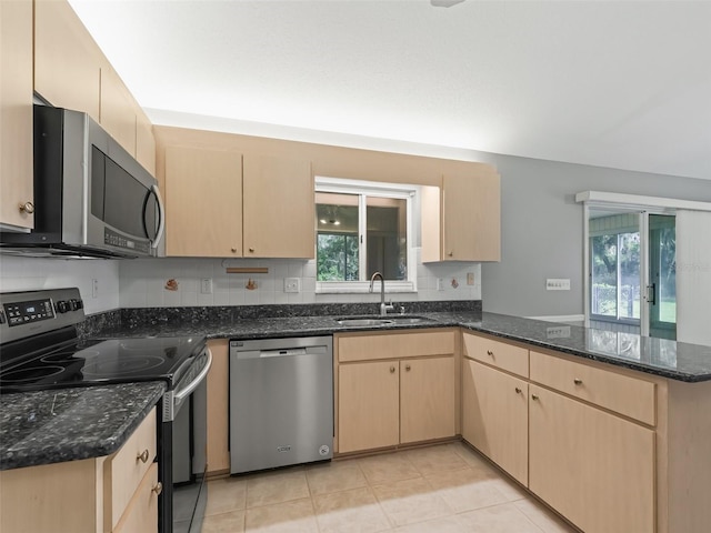 kitchen with a wealth of natural light, kitchen peninsula, appliances with stainless steel finishes, and sink