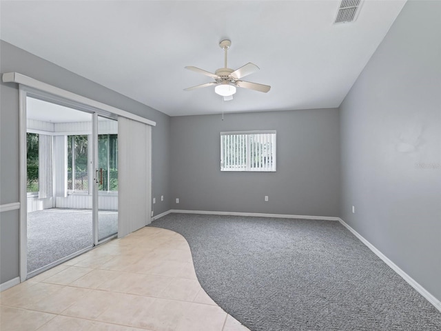 carpeted empty room featuring a wealth of natural light and ceiling fan