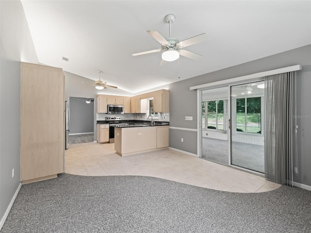 kitchen featuring light brown cabinets, appliances with stainless steel finishes, sink, and vaulted ceiling