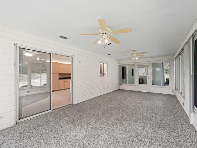 unfurnished living room featuring carpet flooring and ceiling fan