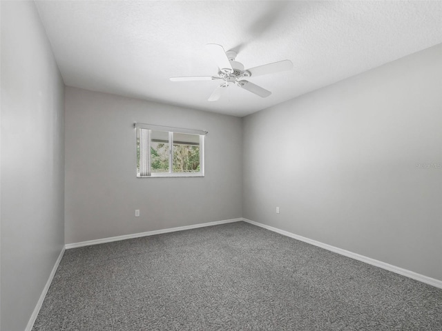 carpeted spare room featuring ceiling fan and a textured ceiling