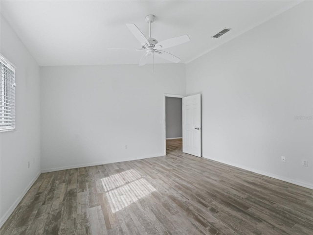 spare room featuring ceiling fan, dark hardwood / wood-style floors, and vaulted ceiling