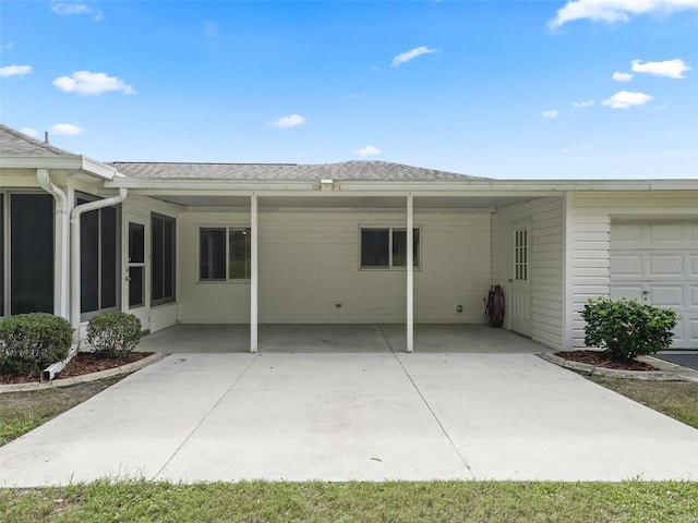 back of property featuring a sunroom and a carport