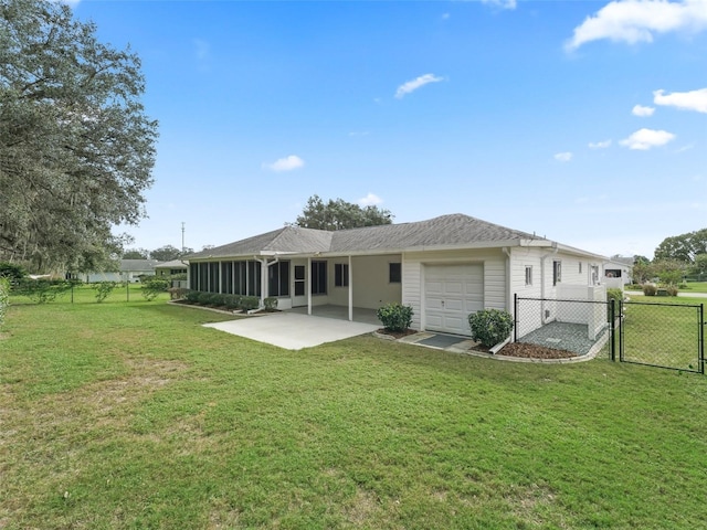 rear view of property with a lawn, a sunroom, a patio, and a garage