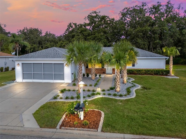 ranch-style house with a garage and a yard