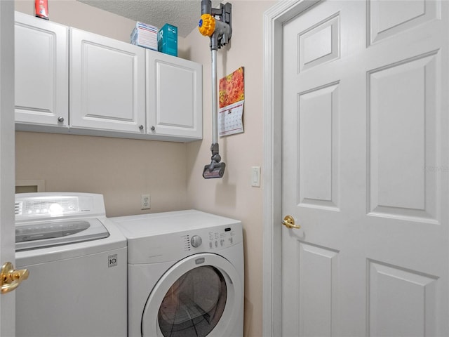 clothes washing area with cabinets, a textured ceiling, and washer and dryer