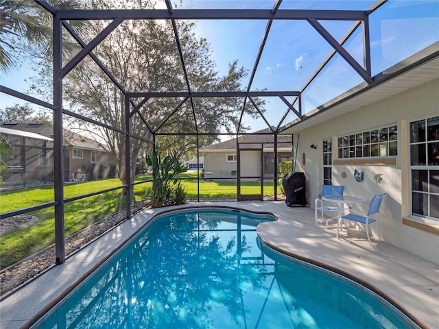 view of swimming pool with glass enclosure, a patio area, area for grilling, and a lawn