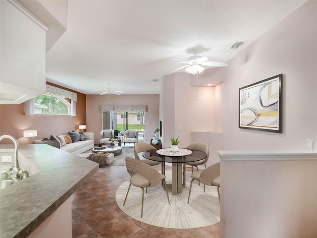 dining room featuring ceiling fan and dark tile patterned flooring