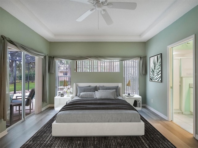 bedroom with ceiling fan, wood-type flooring, access to exterior, and connected bathroom