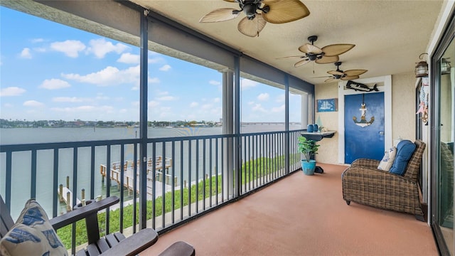 sunroom featuring a water view and ceiling fan