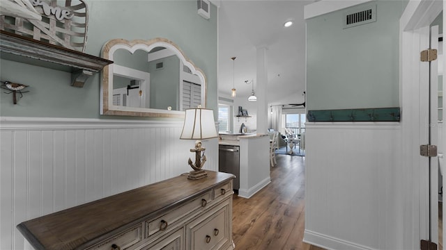 hall featuring lofted ceiling and light hardwood / wood-style flooring