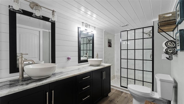 bathroom with vanity, wooden walls, hardwood / wood-style floors, toilet, and a shower with shower door