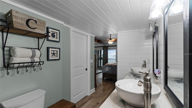 bathroom with hardwood / wood-style floors, ceiling fan, toilet, and sink