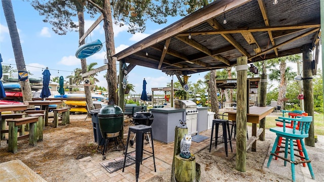 view of patio / terrace featuring a bar, area for grilling, and a gazebo