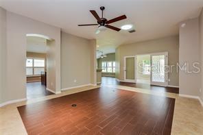 unfurnished living room with hardwood / wood-style floors, ceiling fan, and a wealth of natural light