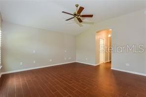 spare room featuring dark hardwood / wood-style flooring and ceiling fan