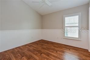 spare room featuring lofted ceiling, ceiling fan, and dark hardwood / wood-style floors