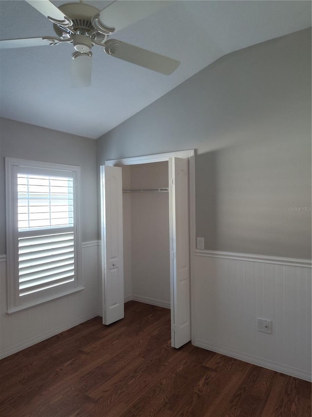 unfurnished bedroom with a closet, vaulted ceiling, ceiling fan, and dark wood-type flooring