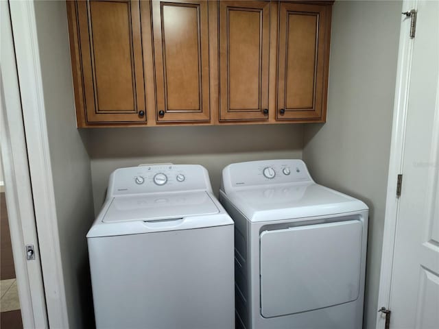 laundry room featuring washing machine and dryer and cabinets