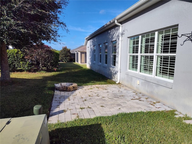 view of yard featuring a patio and an outdoor fire pit