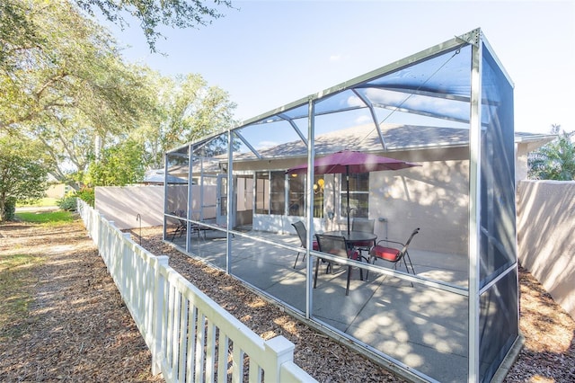 exterior space with glass enclosure and a patio