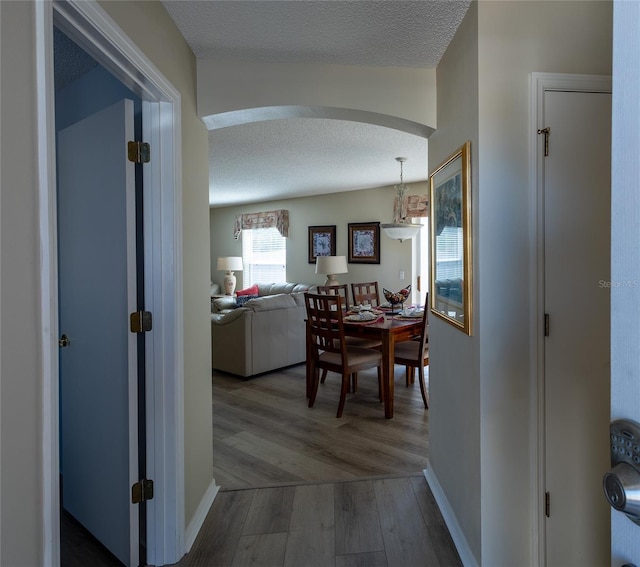 corridor featuring a chandelier, a textured ceiling, and hardwood / wood-style floors