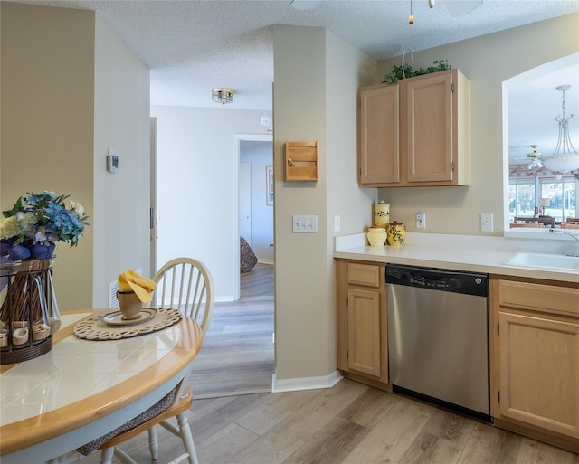 kitchen with dishwasher, sink, light wood-type flooring, light brown cabinets, and a textured ceiling