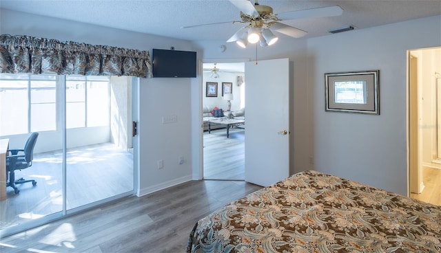 bedroom with ceiling fan, a textured ceiling, and wood-type flooring