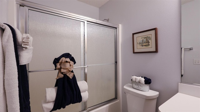 bathroom featuring bath / shower combo with glass door, toilet, and a textured ceiling