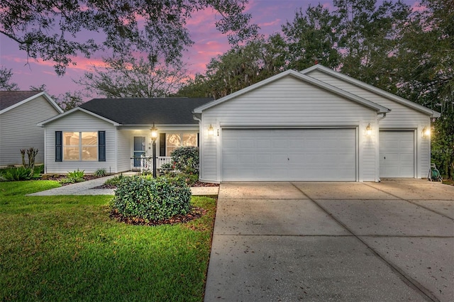 ranch-style home featuring a garage, a yard, and a porch