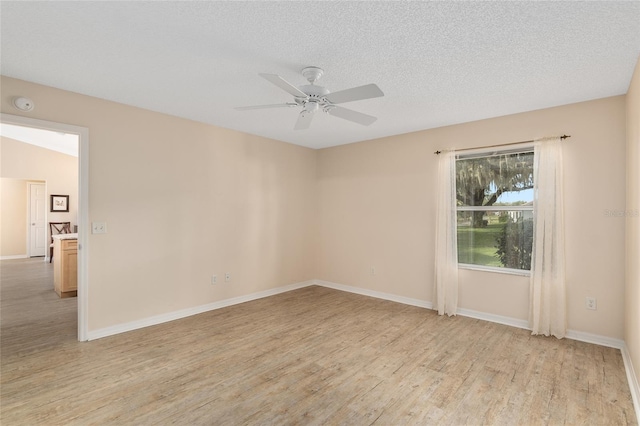 empty room with a textured ceiling, ceiling fan, and light hardwood / wood-style flooring