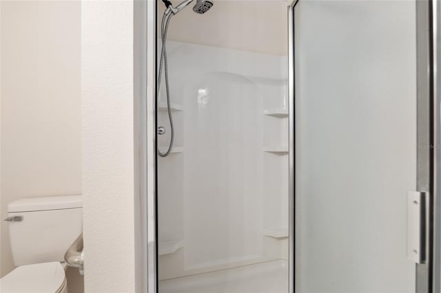 bathroom with an enclosed shower and toilet