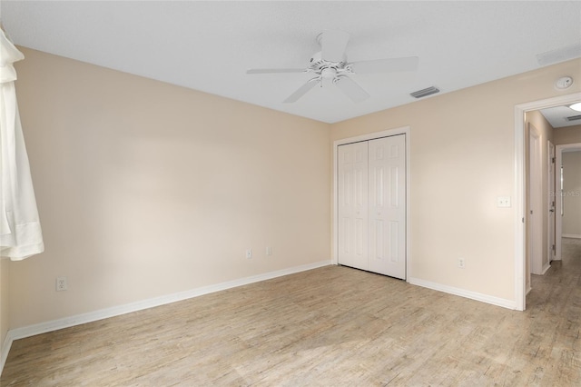 unfurnished bedroom featuring ceiling fan, a closet, and light hardwood / wood-style flooring