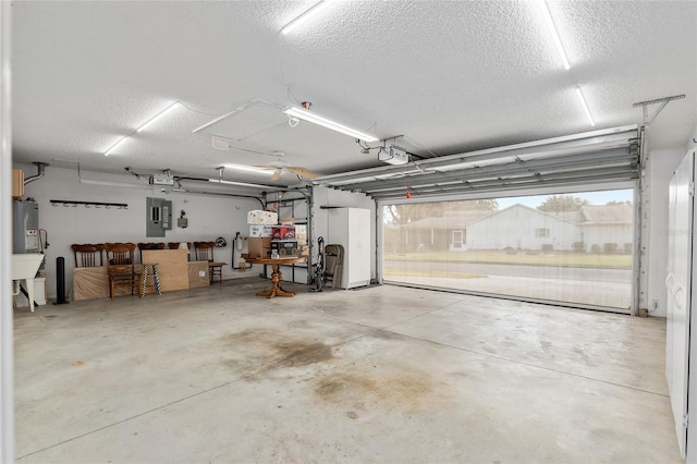 garage featuring electric water heater, electric panel, and a garage door opener