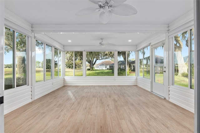 unfurnished sunroom with ceiling fan