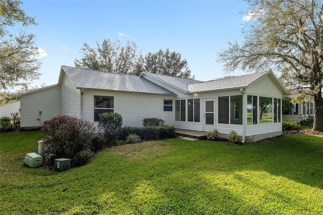 back of house featuring a lawn and a sunroom