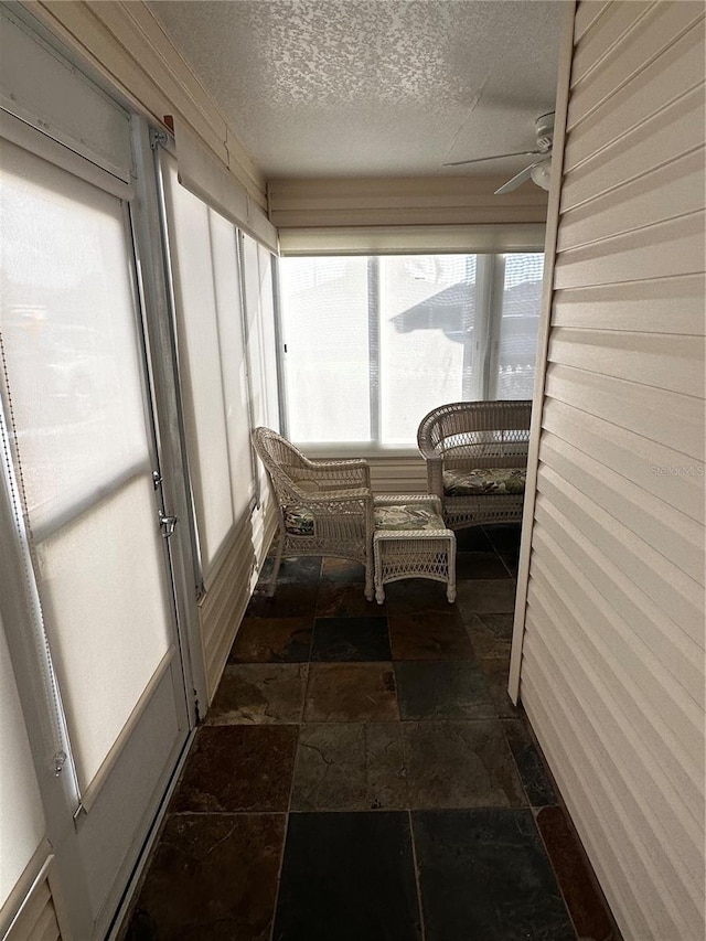 sunroom / solarium featuring ceiling fan