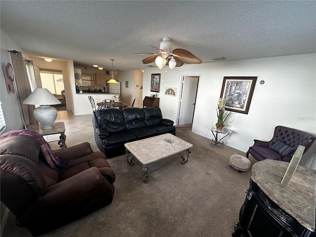 living room with ceiling fan, light carpet, and a textured ceiling