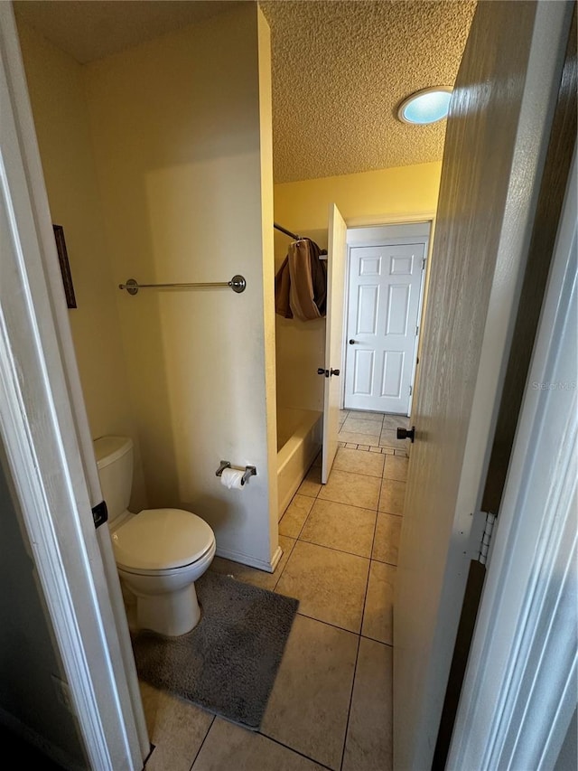 bathroom featuring toilet, shower with separate bathtub, a textured ceiling, and tile patterned floors