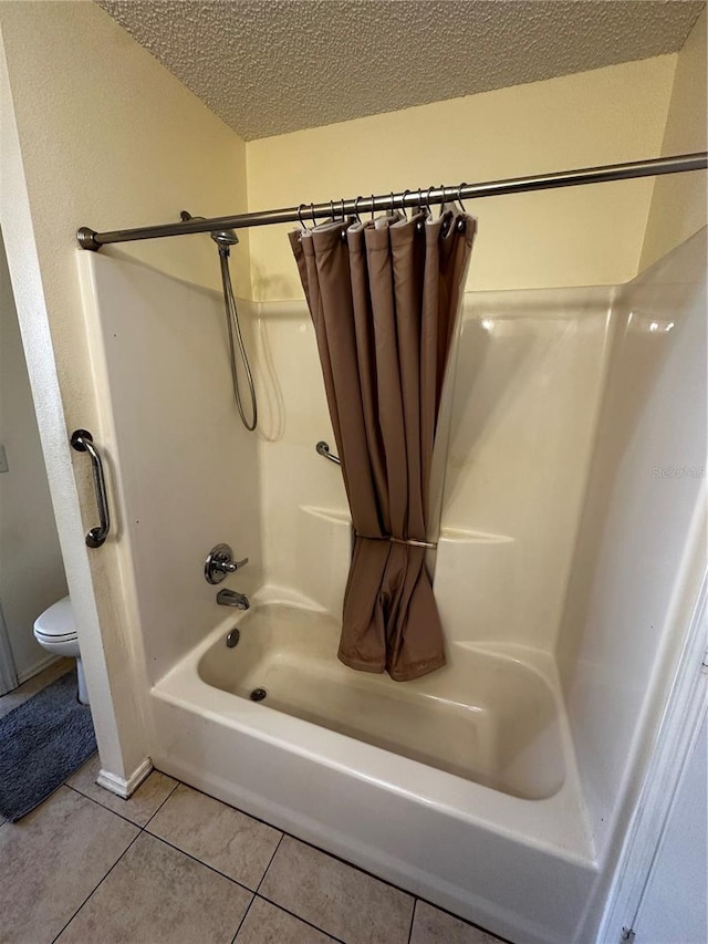 bathroom featuring tile patterned flooring, shower / bath combination with curtain, a textured ceiling, and toilet