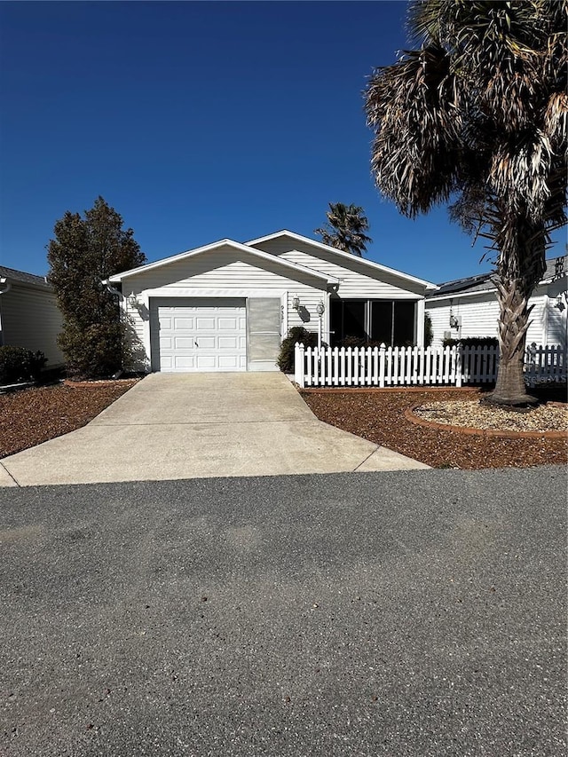 view of front of property featuring a fenced front yard, a garage, and driveway