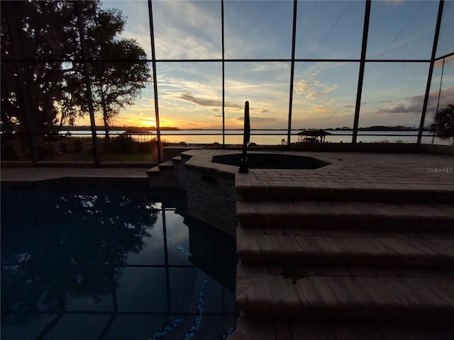 pool at dusk with a water view and sink